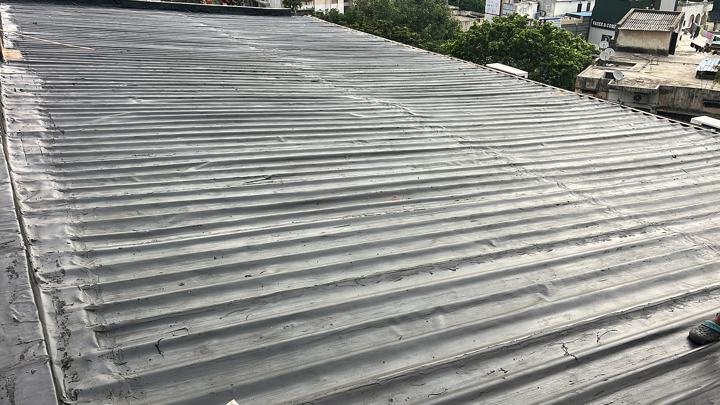 Overlapped sheet membrane on a ribbed metal roof